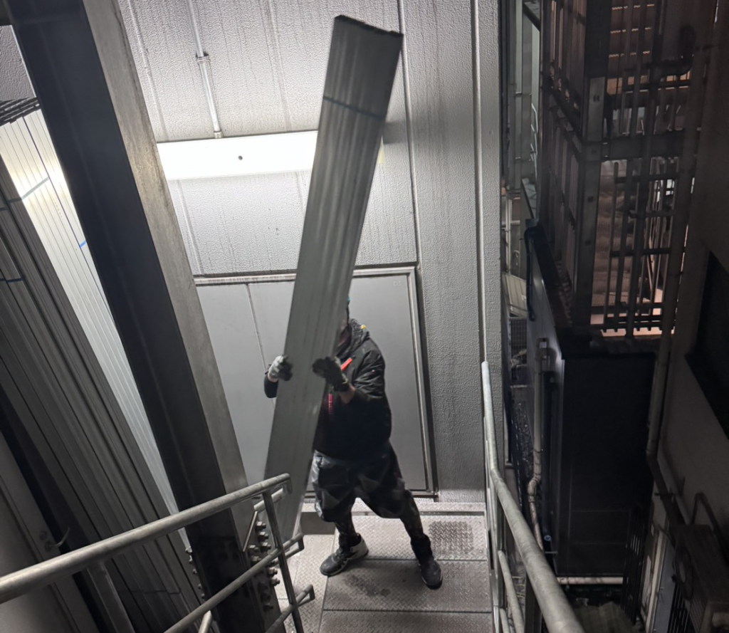 東京・銀座の夜間現場で長尺物・軽量材を4階まで差し上げ搬入する株式会社KIYOGENのスタッフ